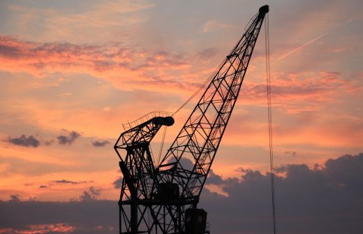 Modernization in industrial cranes sunset sky